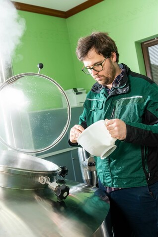 Employee of the traditional Schleicher brewery, Lorenz Döllinger, at work on the tank